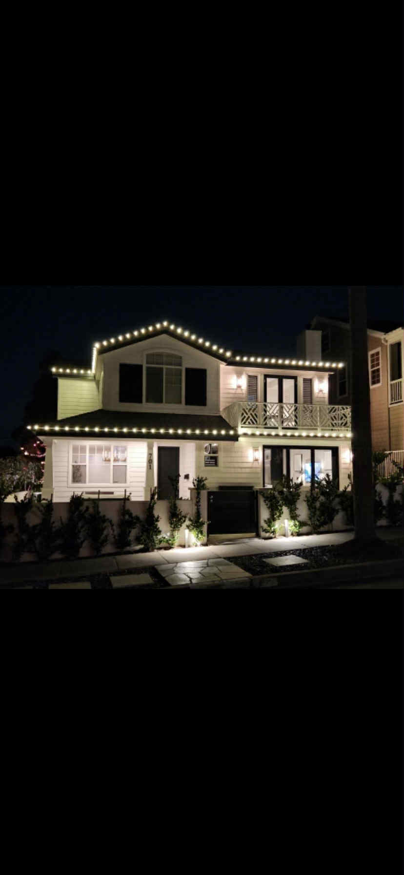 Coastal home with classic warm white roofline lights